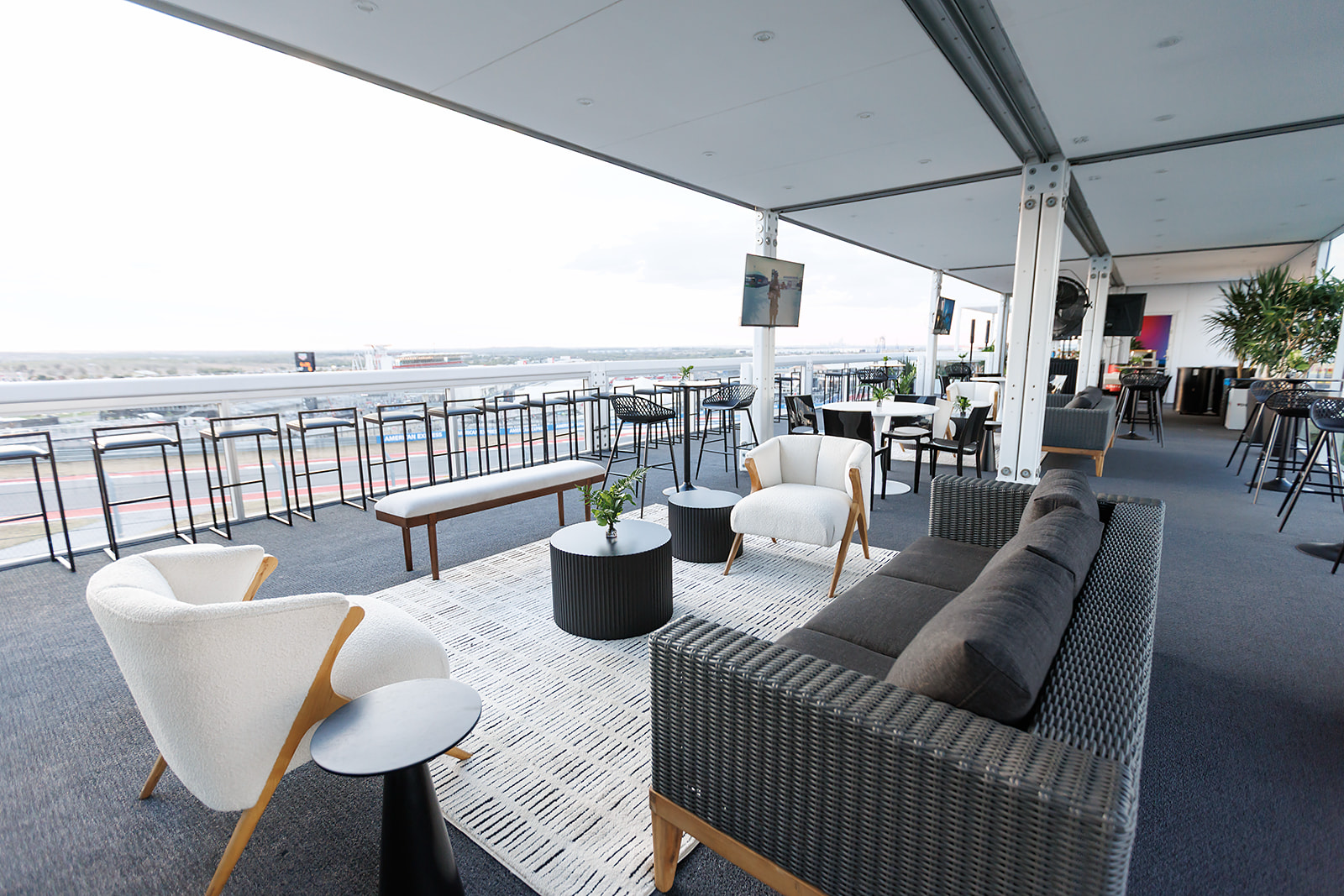 Guests watching Formula 1 cars from a glass-fronted climate-controlled trackside suite