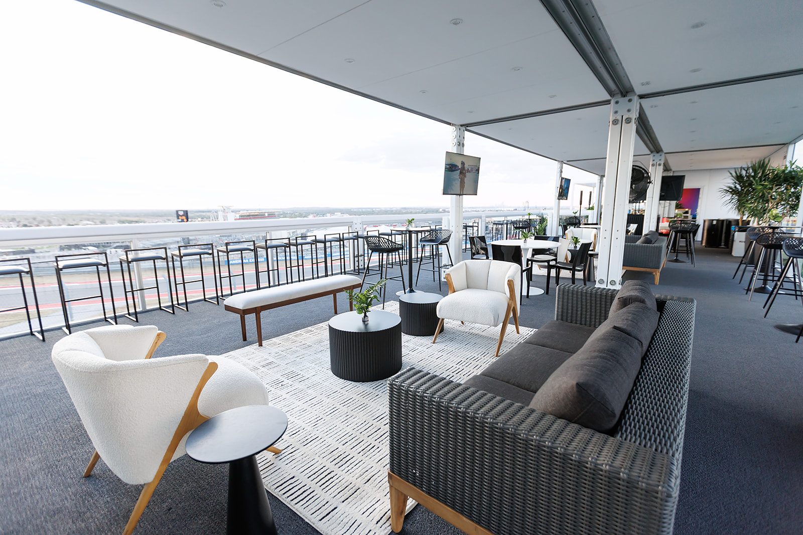 Guests watching Formula 1 cars from a glass-fronted climate-controlled trackside suite